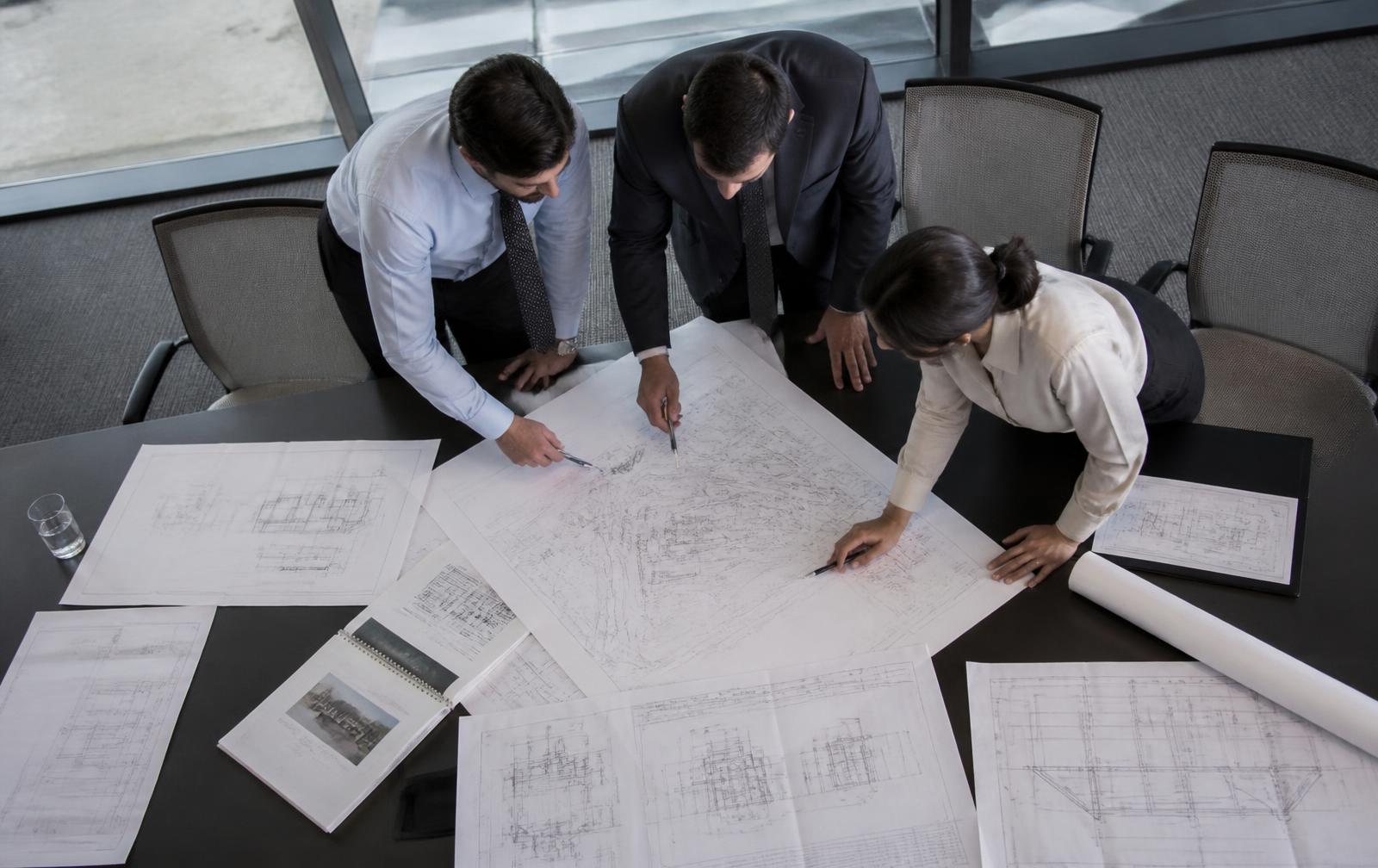 Engineers reviewing system architecture drawings